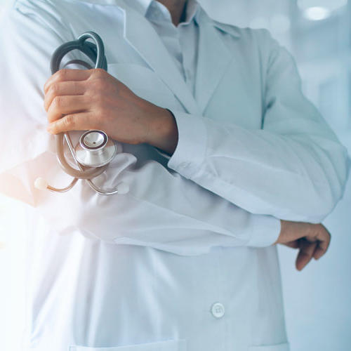 Doctor in long white coat holding stethoscope 