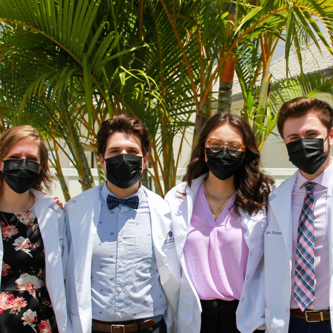 group photo of students in Barbados wearing white coats and face masks