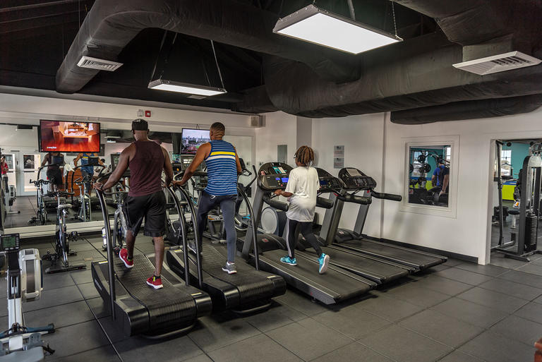 People running on treadmills in fitness center
