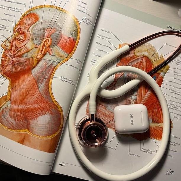 medical textbook with stethoscope and engraved airpods