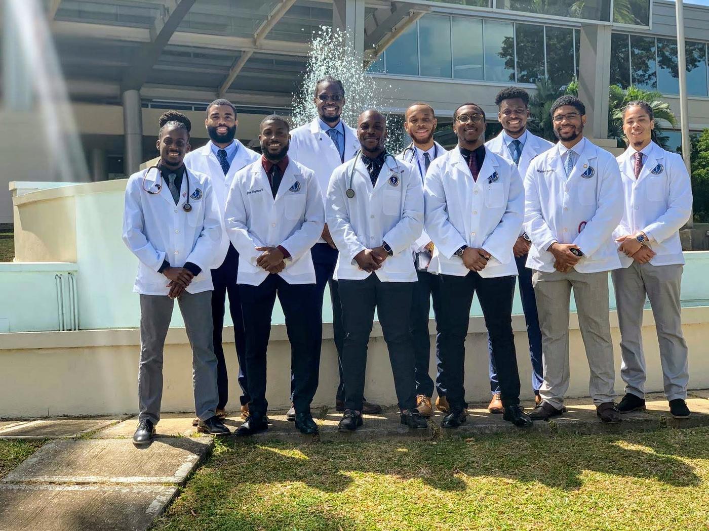 Ten students in white coats outside of the LESC